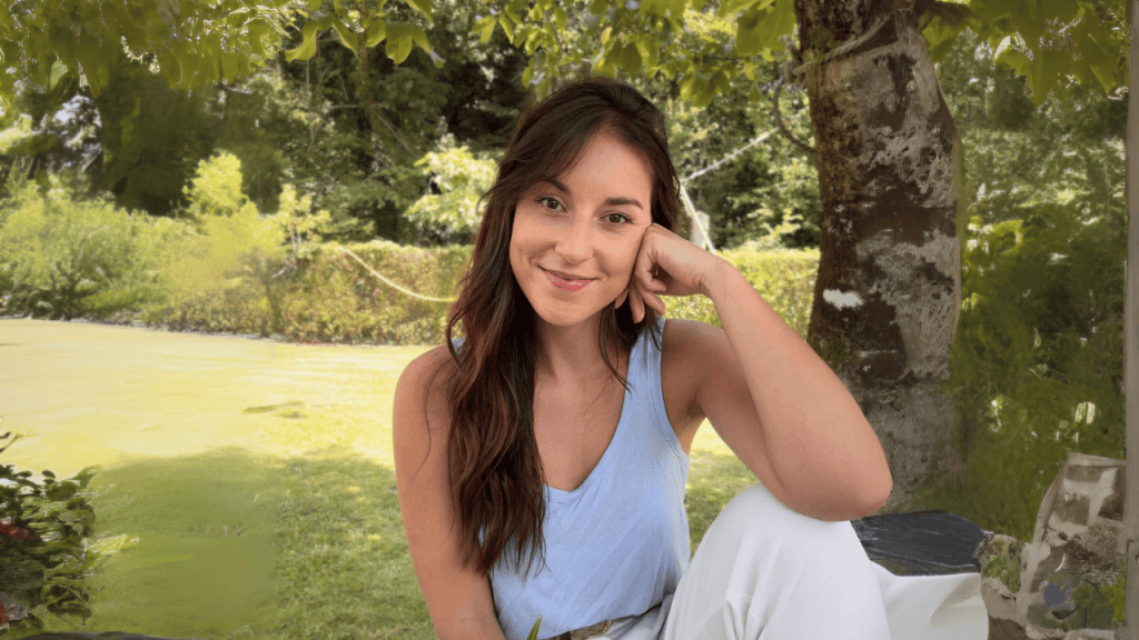 María Leirós, Doctora en Neurociencia y Psicología Clínica, posa sentada en un jardín.